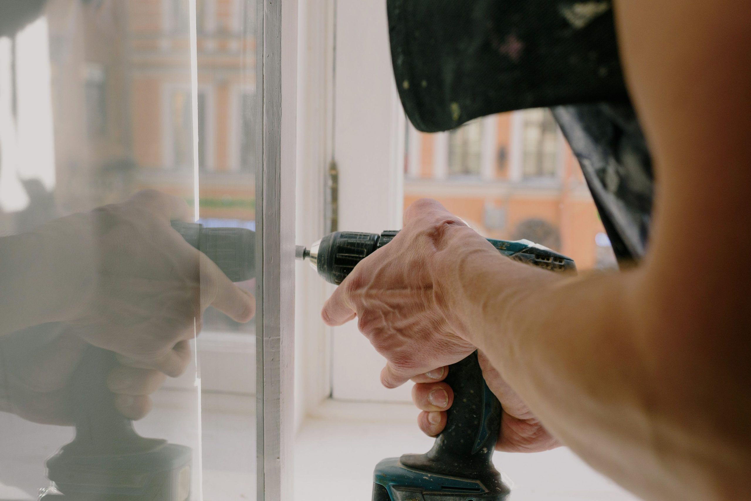Professionnel installant fenêtre avec perceuse sans fil
