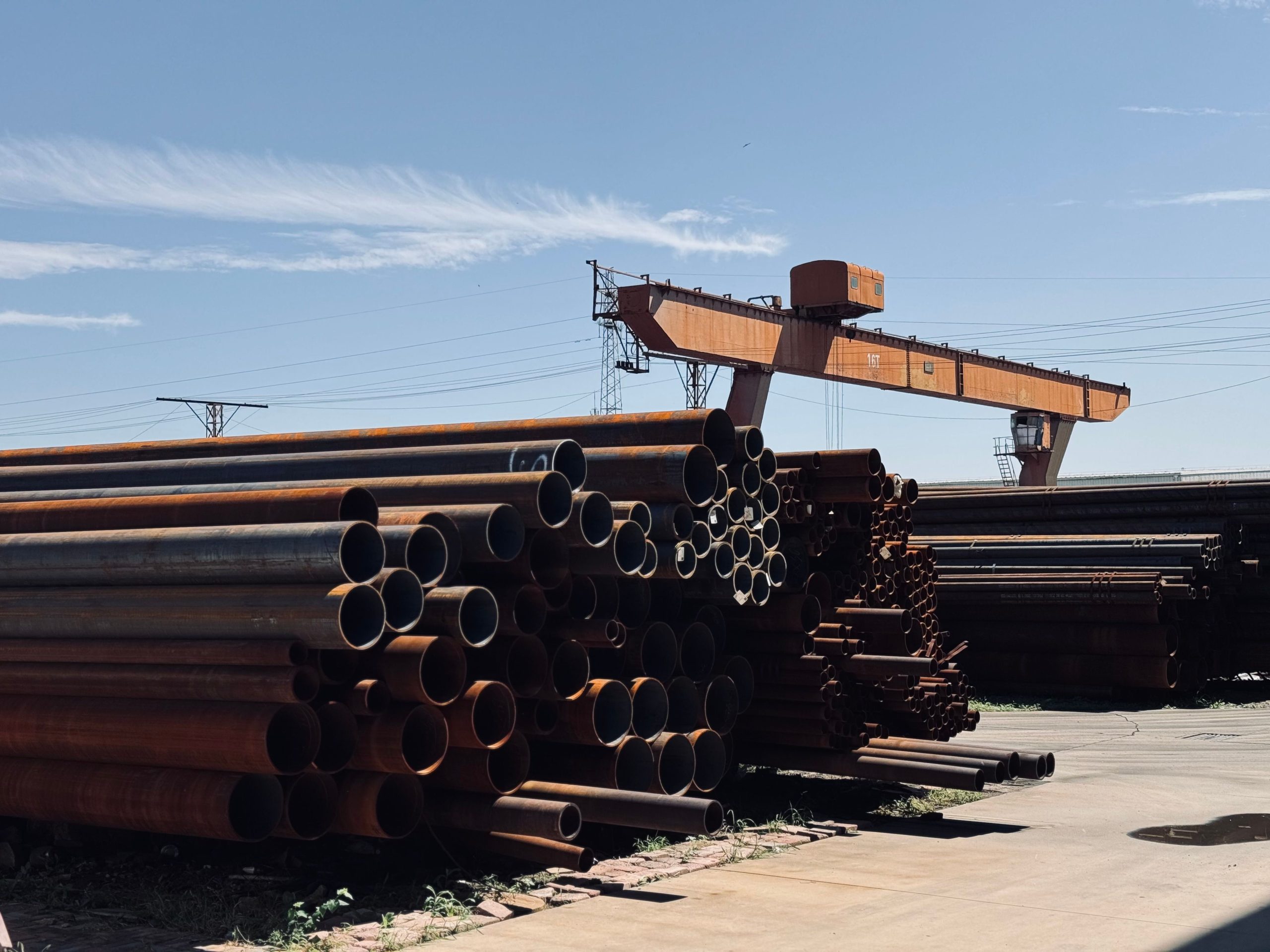 Tuyaux acier empilés avec grue industrielle