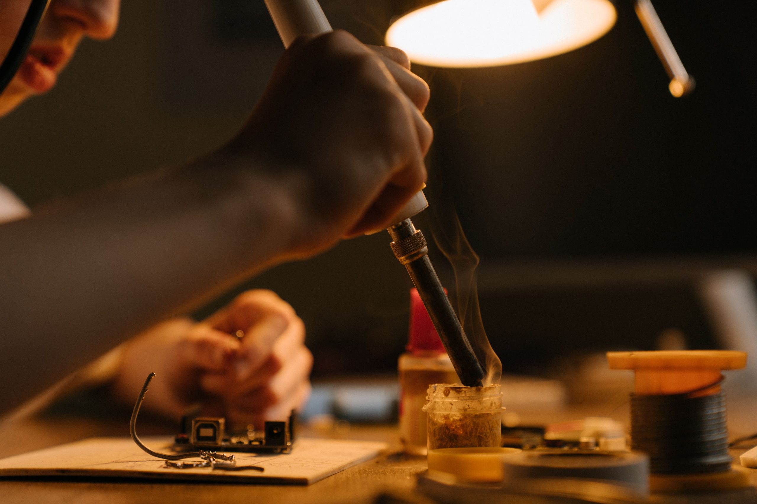 Technicien soudant circuit imprimé sous lampe