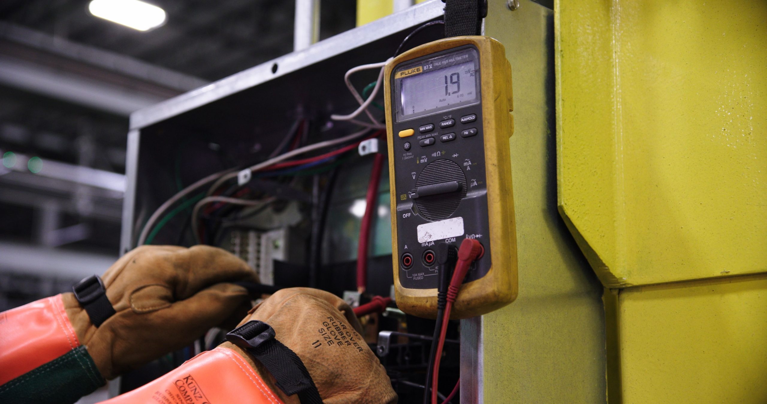 Électricien testant un panneau de contrôle industriel